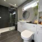 Modern bathroom with vanity unit, walk-in shower and toilet