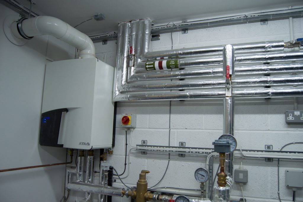 Commercial plant room with boilers and insulated pipework