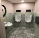 Commercial washroom with urinals and patterned floor tiles