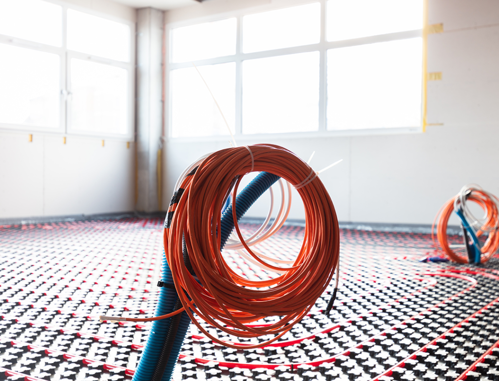 Underfloor heating pipes being laid in a room