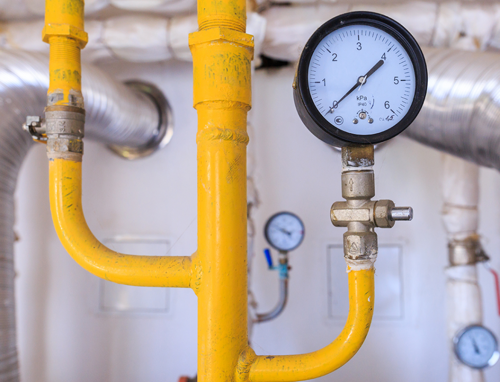 Yellow gas pipework with a pressure gauge